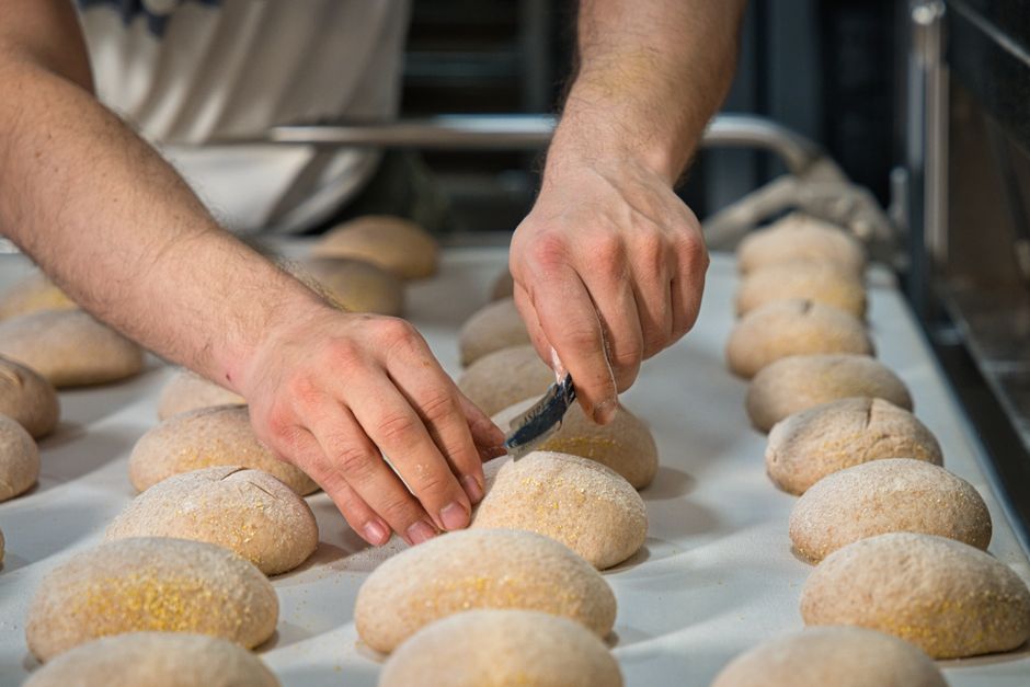 Baker som former små brød for hånd