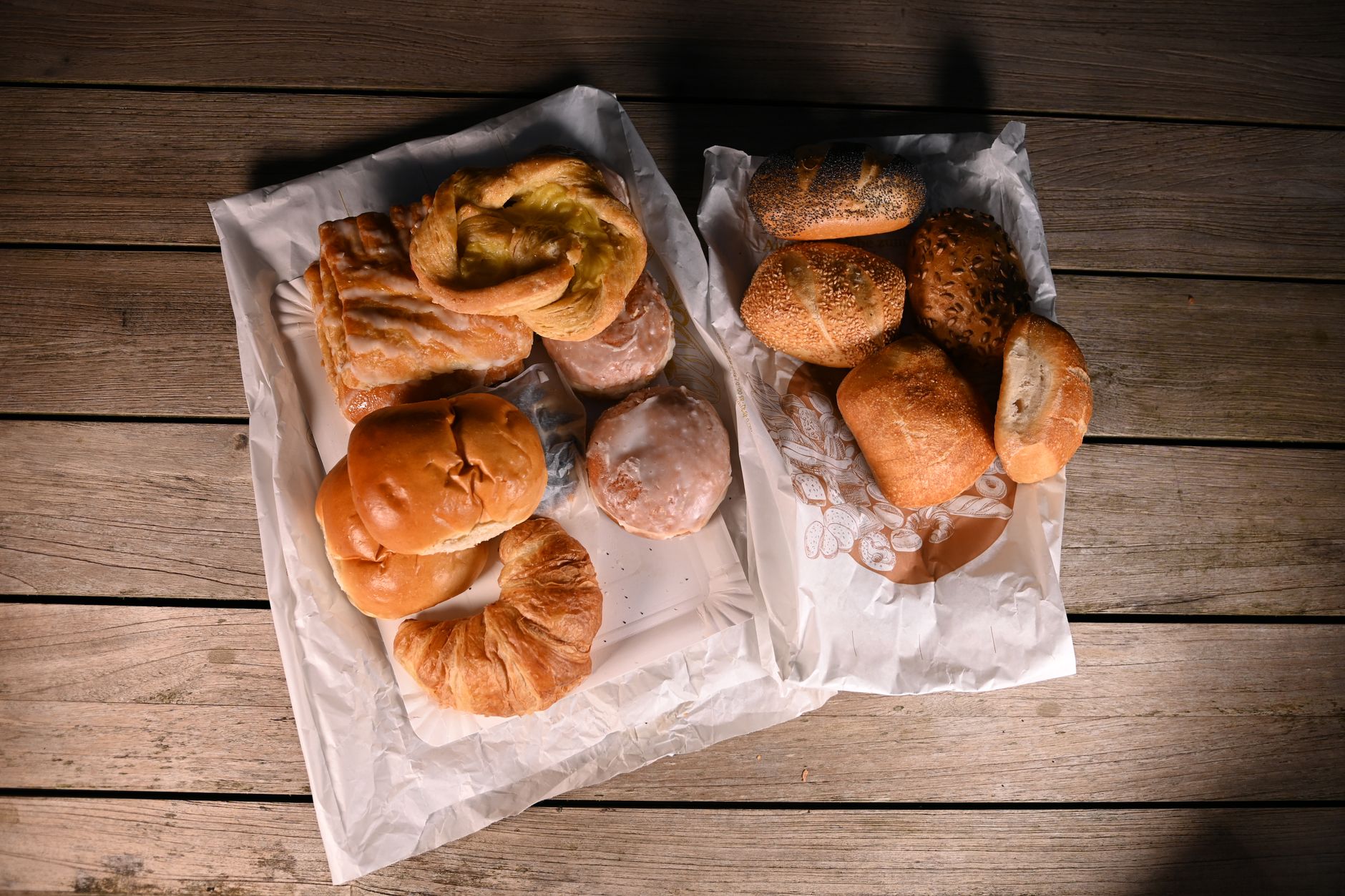Et variert utvalg ferske brød og bakverk på et trebord